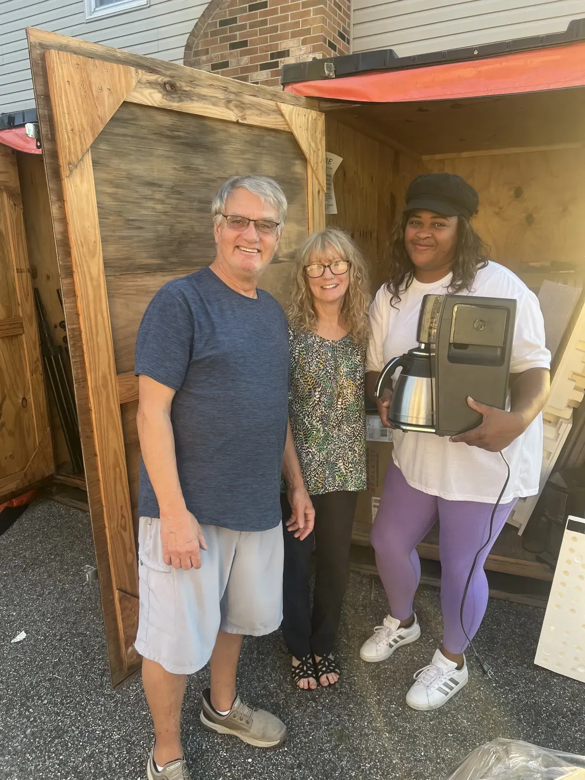 Tom and Lauren Brie with Candis Epps, Vice President and Treasurer of Sledge Empowerment, at the donation pickup