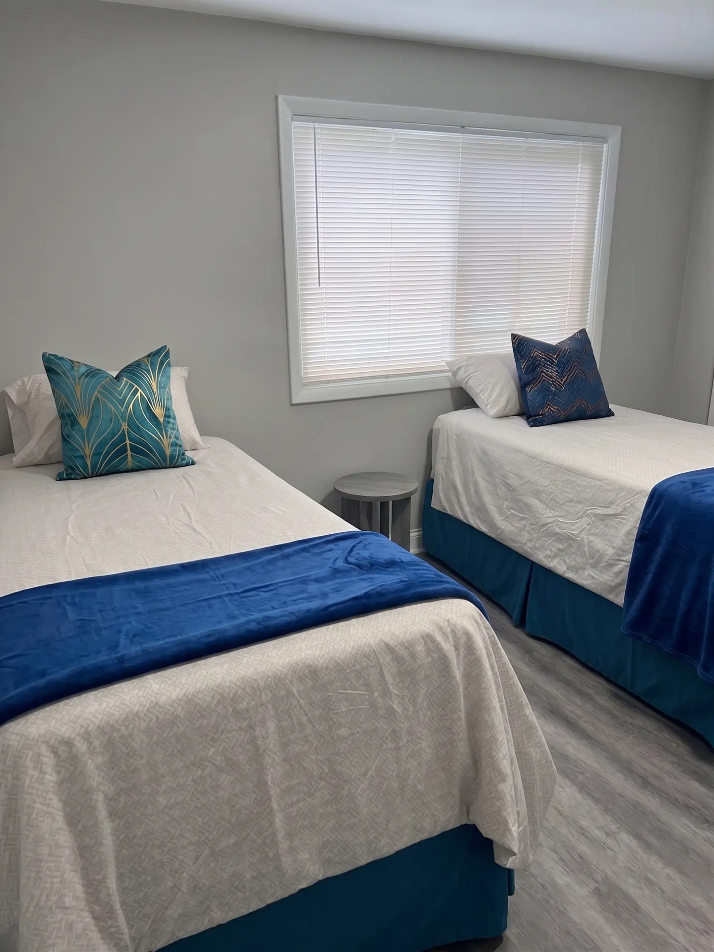Furnished bedroom with twin beds and decorative pillows, a second view