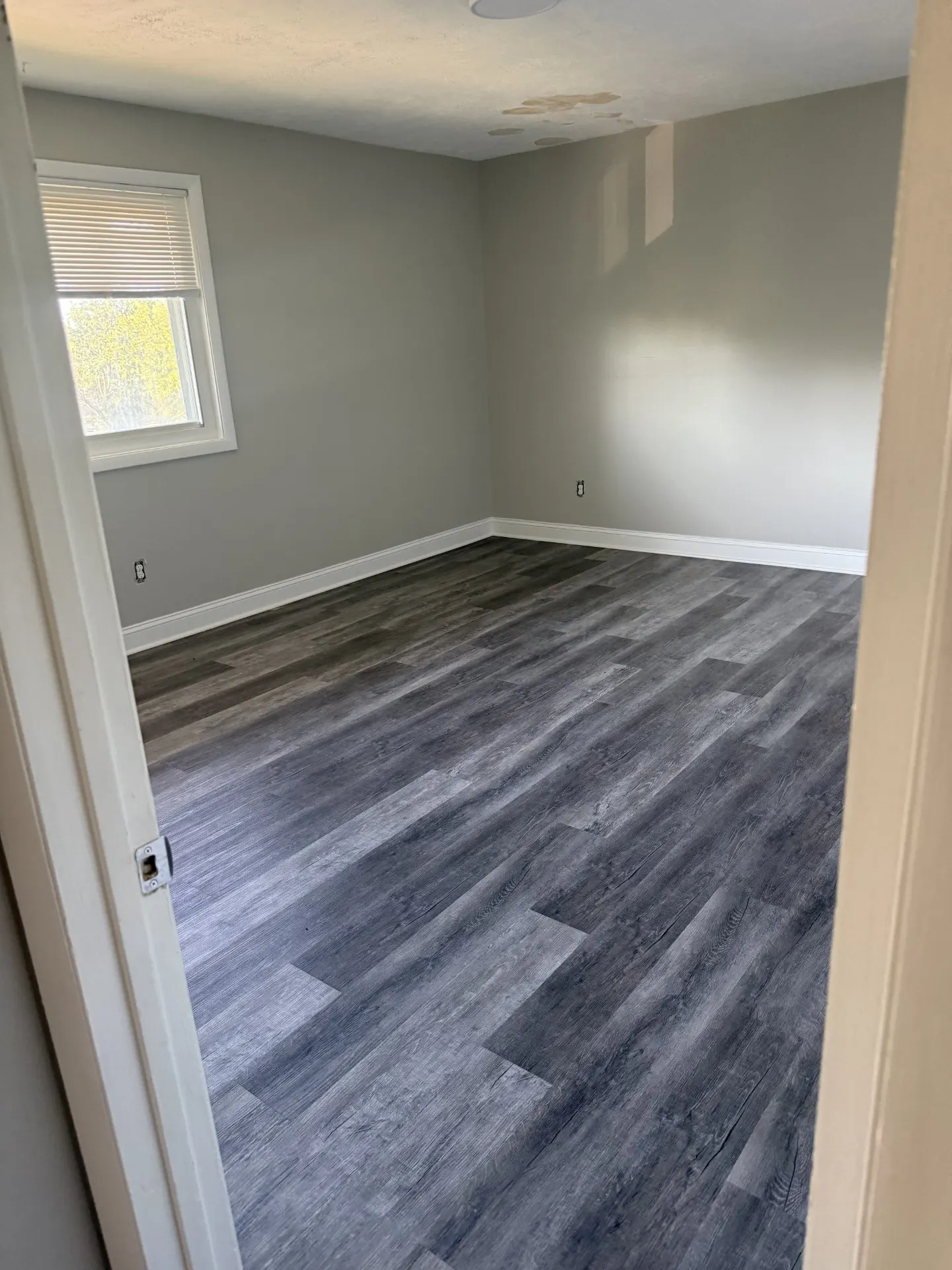 Freshly painted bedroom with new flooring, awaiting furniture