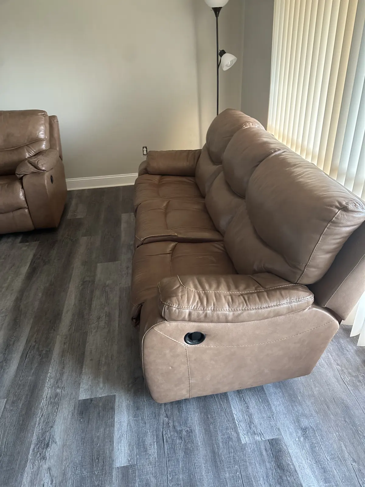 Brown leather reclining sofa and loveseat in a bright living room